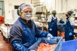 A worker processing salmon at a plant.